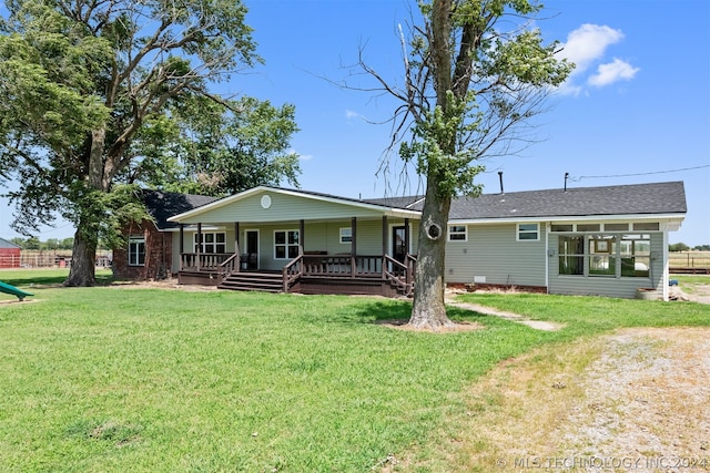 back of property featuring a lawn and covered porch