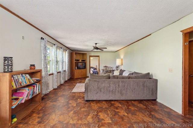 living room featuring ceiling fan, ornamental molding, and a textured ceiling