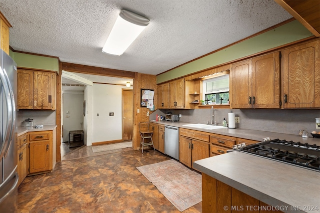 kitchen with crown molding, appliances with stainless steel finishes, sink, and a textured ceiling