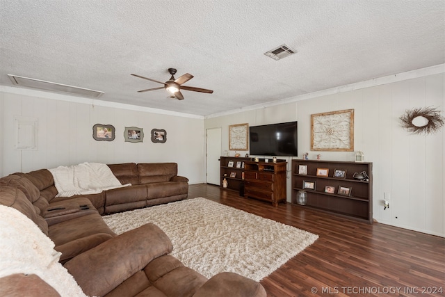 living room featuring dark hardwood / wood-style flooring, ceiling fan, ornamental molding, and a textured ceiling