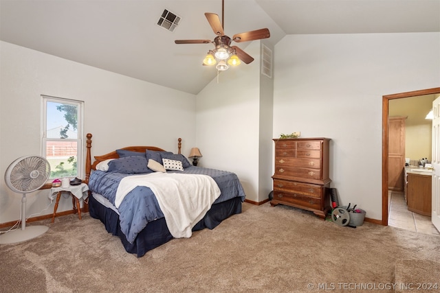 bedroom featuring ceiling fan, ensuite bathroom, light colored carpet, and lofted ceiling