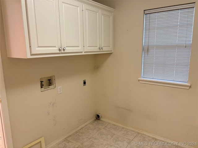 clothes washing area with cabinets, electric dryer hookup, and washer hookup