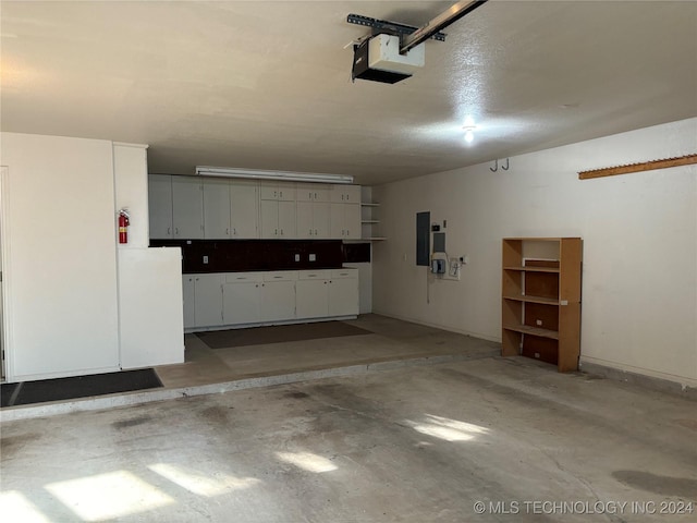 garage with a garage door opener and electric panel