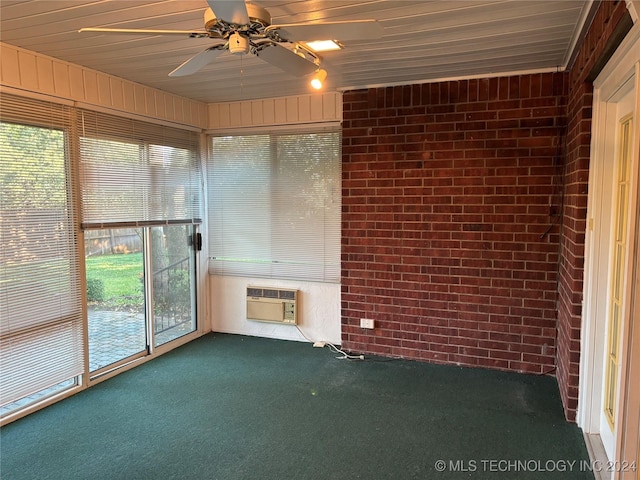 unfurnished sunroom featuring a wall mounted AC, wooden ceiling, and ceiling fan