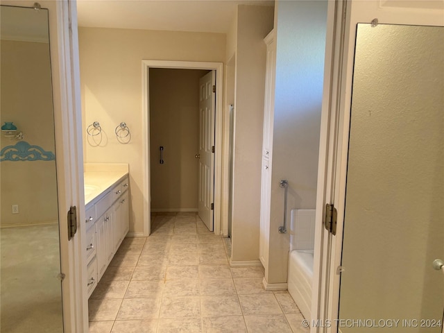 bathroom featuring vanity, tile patterned floors, and a bathing tub