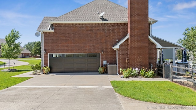 view of side of home with central AC and a garage