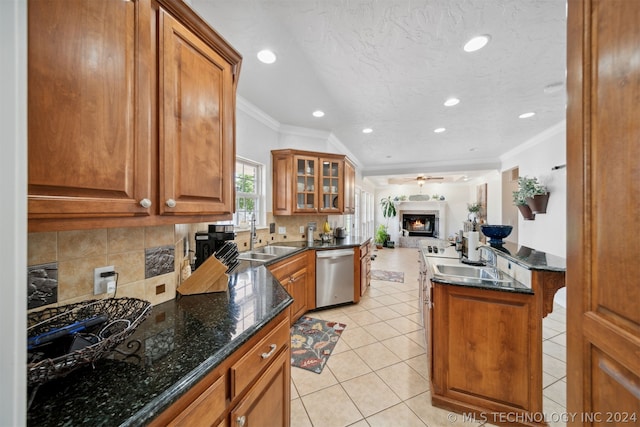 kitchen featuring dishwasher, ornamental molding, ceiling fan, dark stone counters, and backsplash