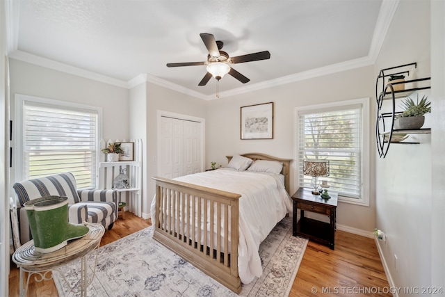 bedroom with ornamental molding, ceiling fan, a closet, and light hardwood / wood-style flooring