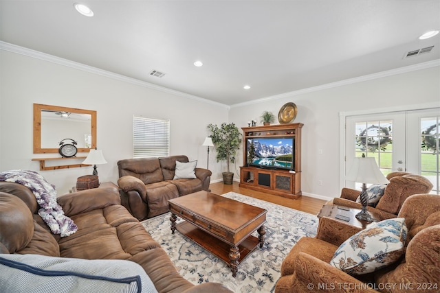 living room featuring french doors, crown molding, and light hardwood / wood-style flooring