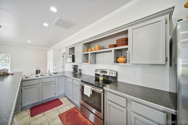 kitchen with stainless steel appliances, ornamental molding, sink, and gray cabinetry