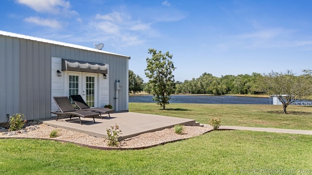 view of yard featuring french doors, a patio, and a water view