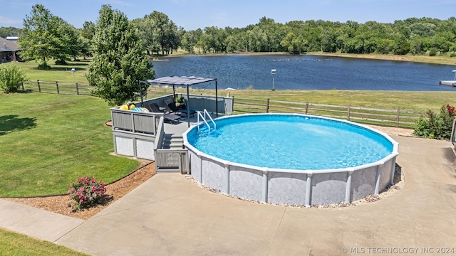 view of pool with a lawn and a water view