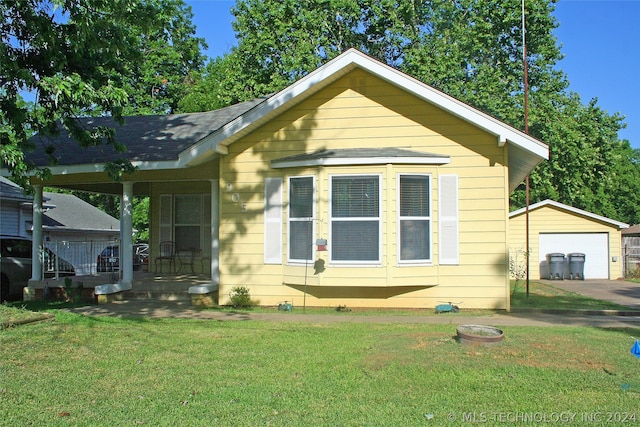 bungalow-style home featuring an outbuilding, a front yard, and a garage