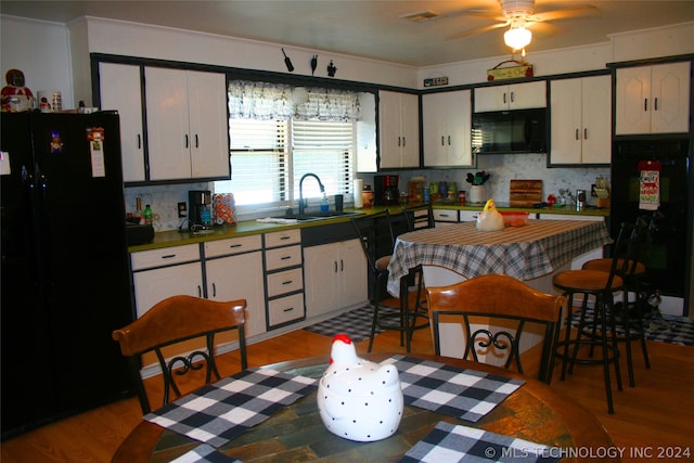 kitchen featuring light hardwood / wood-style flooring, black appliances, white cabinetry, ceiling fan, and sink