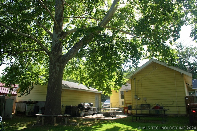 rear view of house featuring a lawn and a patio area