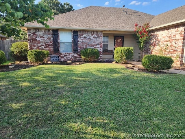 single story home featuring a front lawn