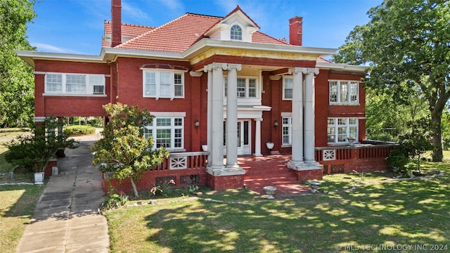 greek revival inspired property featuring a porch and a front lawn