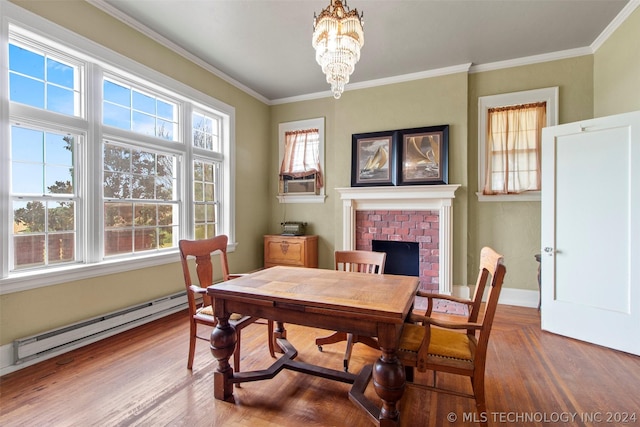 dining area featuring crown molding, wood-type flooring, baseboard heating, and an inviting chandelier