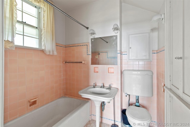 bathroom with tiled shower / bath, toilet, and tile walls