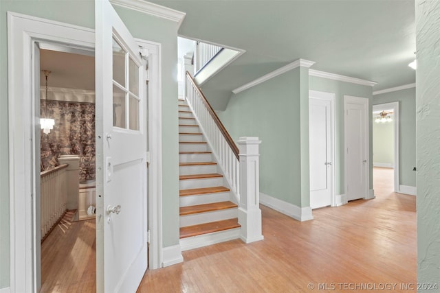 staircase with hardwood / wood-style flooring and ornamental molding