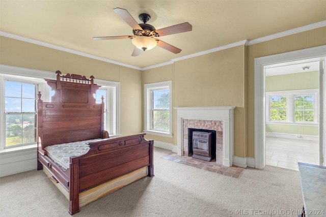 bedroom featuring a brick fireplace, ceiling fan, light carpet, and multiple windows