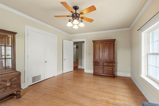 unfurnished bedroom featuring a closet, light hardwood / wood-style floors, ceiling fan, and crown molding