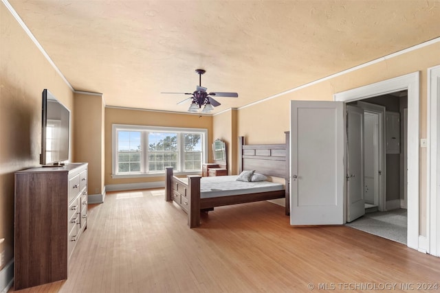 bedroom with a textured ceiling, ceiling fan, light wood-type flooring, and ornamental molding