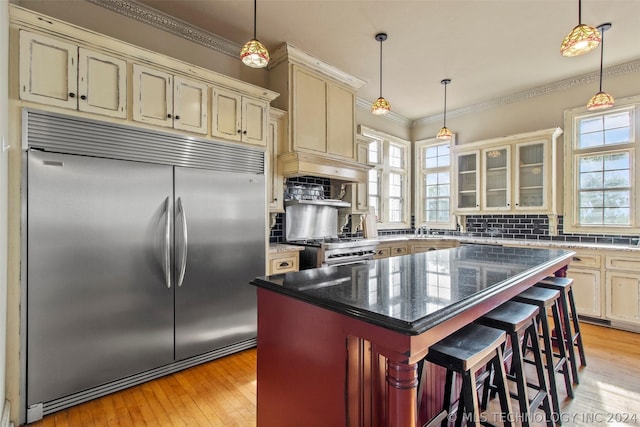 kitchen featuring a breakfast bar area, cream cabinets, a kitchen island, and premium appliances