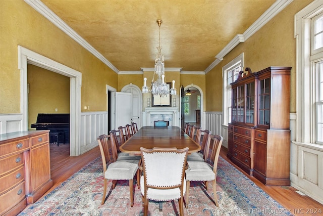 dining room with a notable chandelier, light wood-type flooring, and ornamental molding