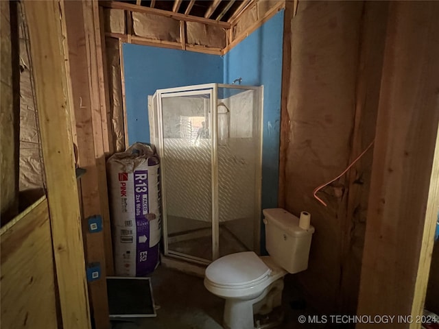 bathroom featuring toilet and an enclosed shower