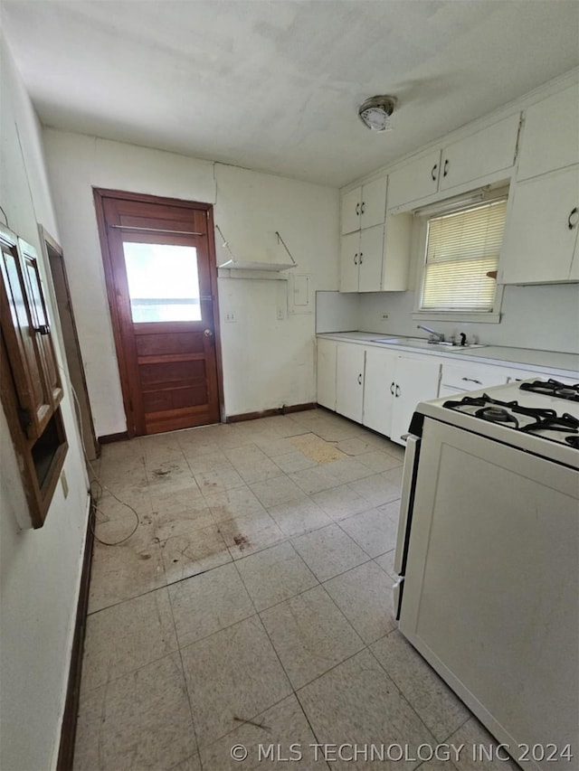 303 S B, Davis, OK 73030 - kitchen with baseboards, white cabinets, light countertops, and white gas stove