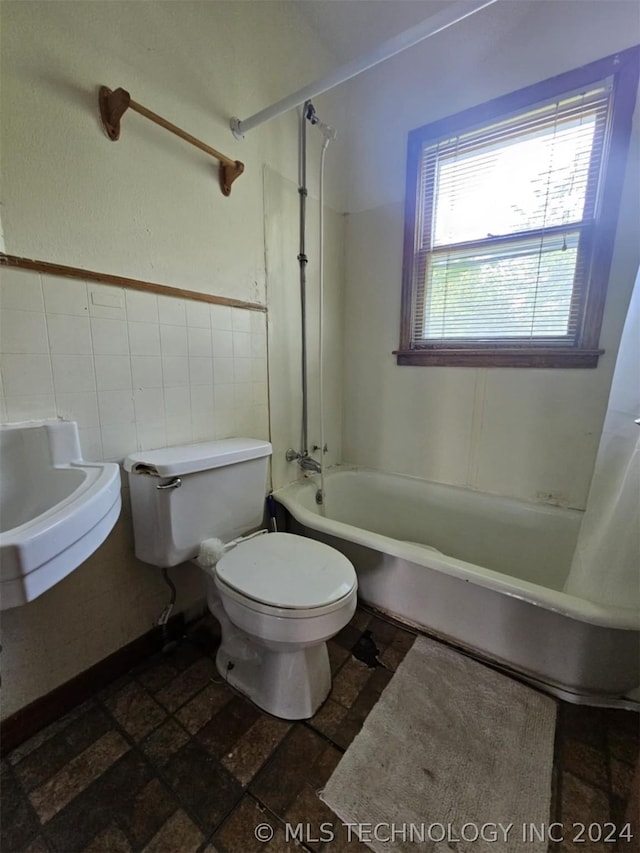 303 S B, Davis, OK 73030 - bathroom with tile walls, stone tile flooring, shower / bathtub combination with curtain, toilet, and a sink