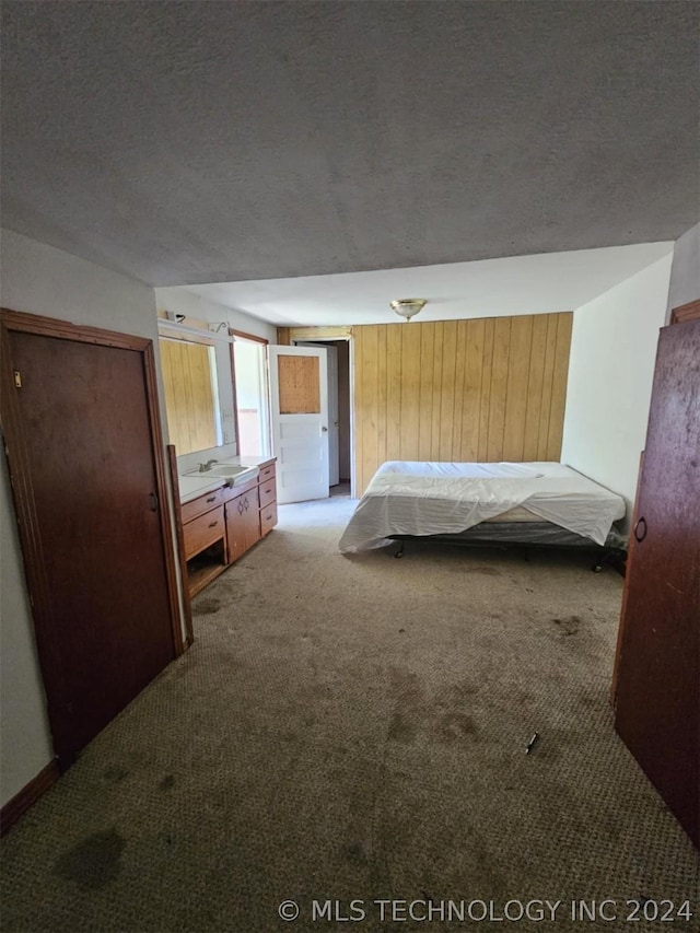 303 S B, Davis, OK 73030 - unfurnished bedroom with a textured ceiling and light colored carpet