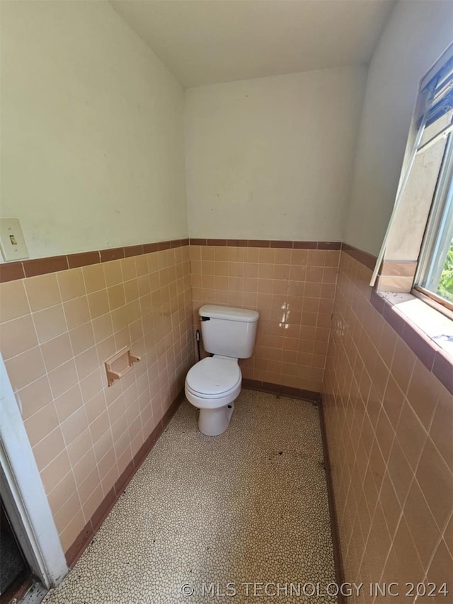 303 S B, Davis, OK 73030 - half bathroom with toilet, tile walls, and wainscoting