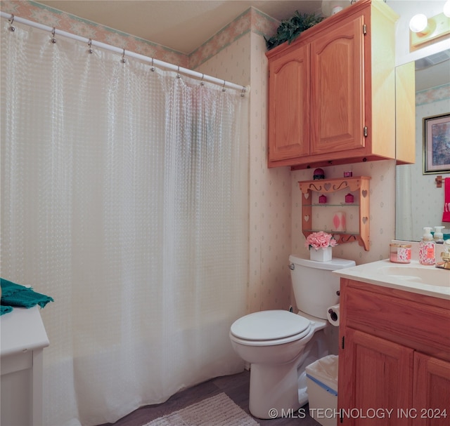 bathroom featuring a shower with curtain, vanity, and toilet