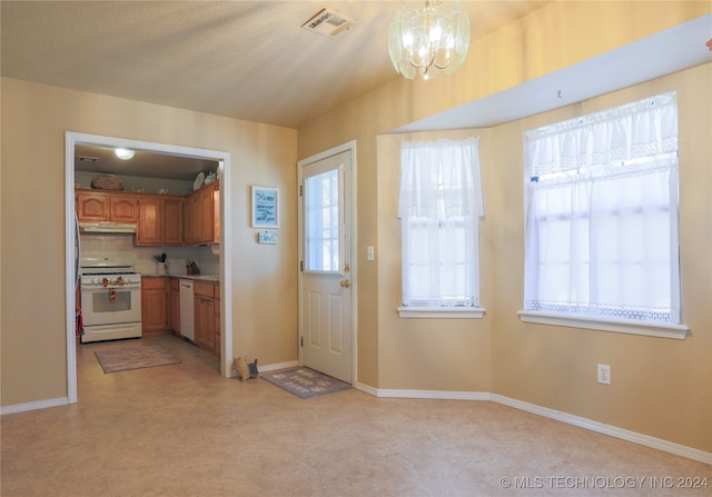 entryway with a wealth of natural light and a notable chandelier