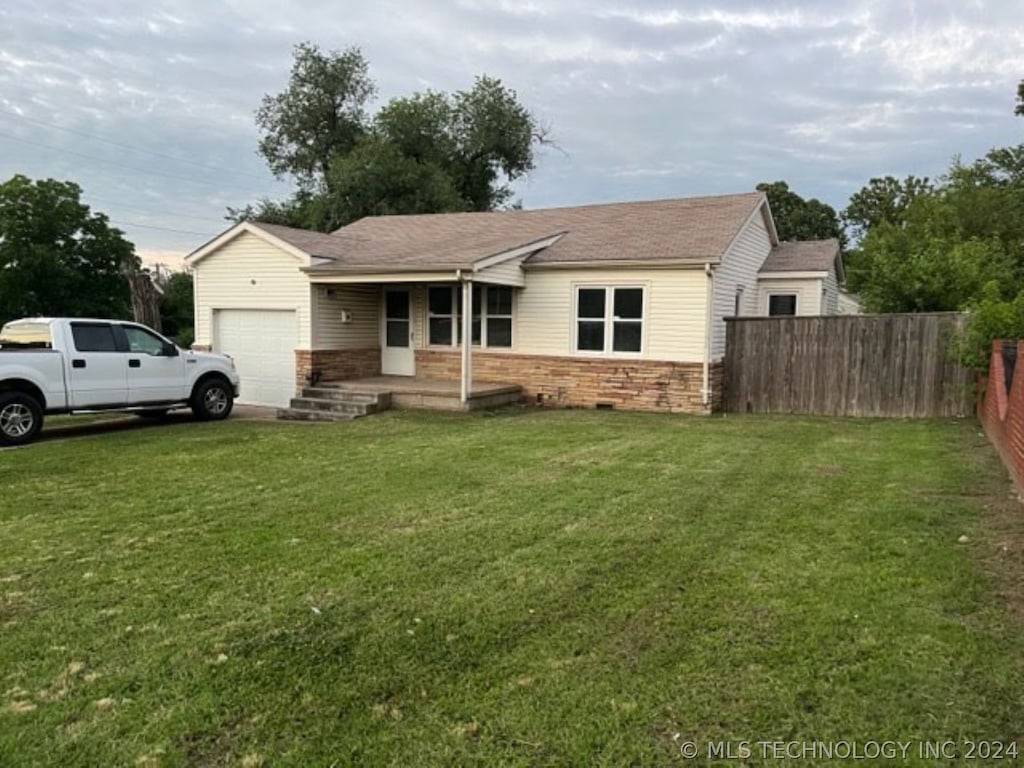 ranch-style home with a garage and a front lawn