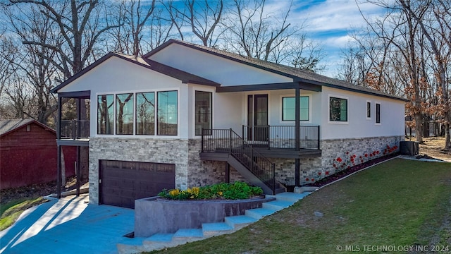 view of front of property with driveway, stone siding, a front yard, a porch, and a garage