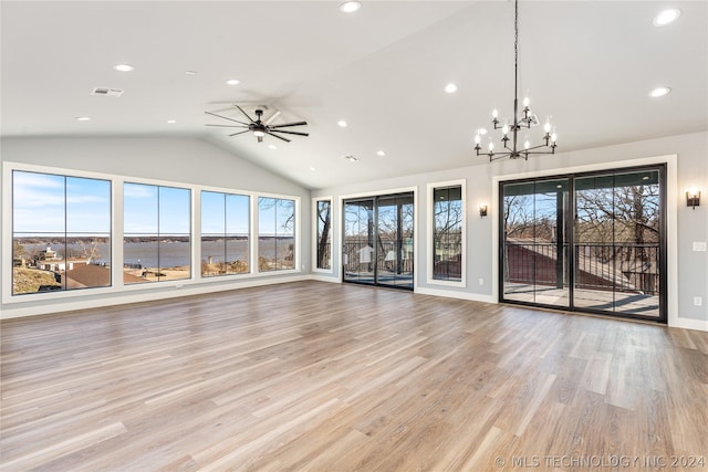 unfurnished living room with lofted ceiling, ceiling fan with notable chandelier, light hardwood / wood-style flooring, and a water view