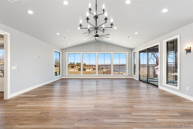 unfurnished living room featuring light wood-style floors, recessed lighting, a chandelier, lofted ceiling, and baseboards