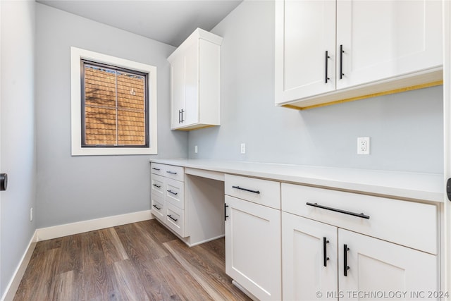 kitchen with white cabinets, dark wood-style flooring, light countertops, and baseboards