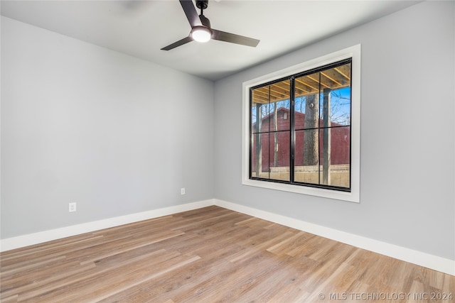spare room with wood finished floors, ceiling fan, and baseboards