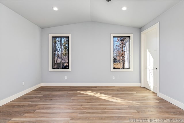 interior space with light wood-style flooring, baseboards, vaulted ceiling, and recessed lighting