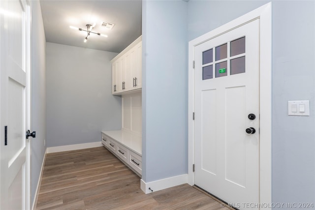 mudroom featuring light wood finished floors, visible vents, and baseboards
