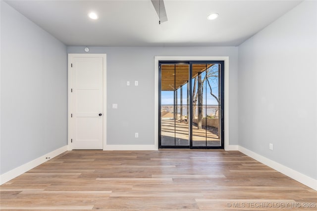 spare room featuring baseboards, recessed lighting, and light wood finished floors