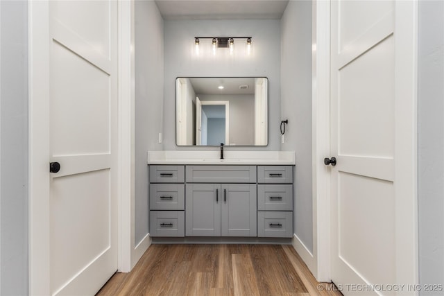 bathroom featuring baseboards, vanity, and wood finished floors