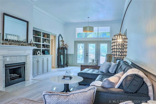 living room featuring crown molding, a premium fireplace, and built in features