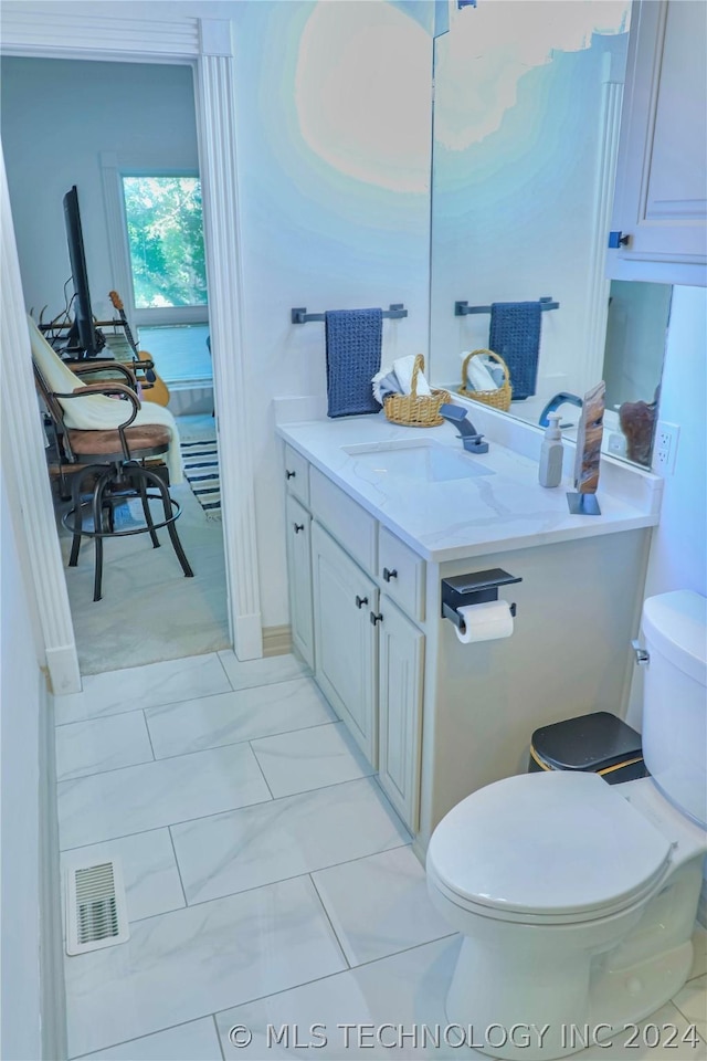 bathroom with vanity, tile patterned floors, and toilet