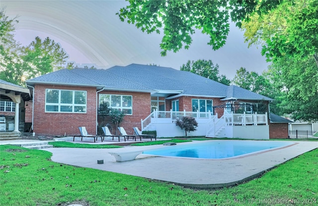 rear view of house featuring a patio and a yard