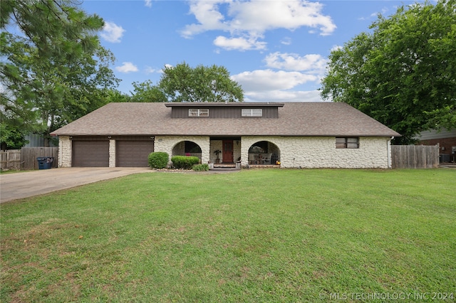 view of front of house with a garage and a front lawn